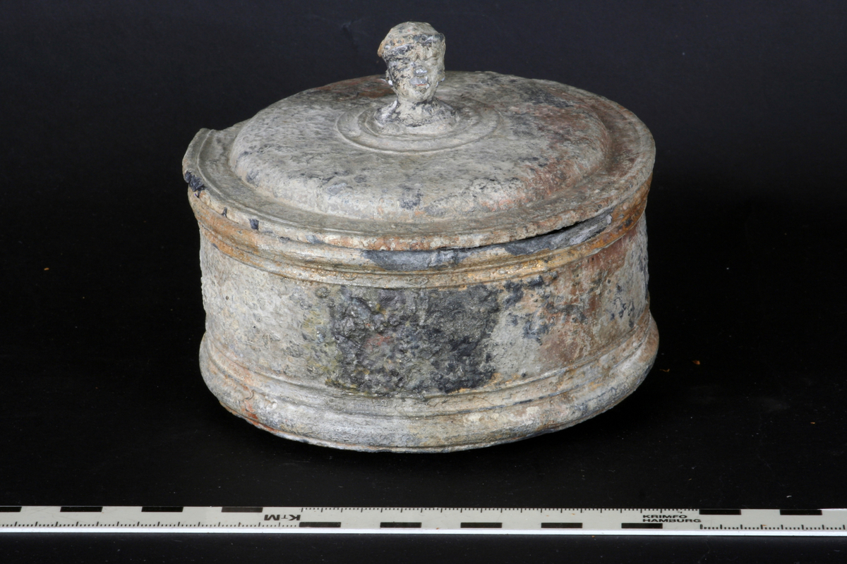 Tobaksburk med innerlock, som sjunker med innehållet och därvid håller det fräscht , prytt med drake i brons/guldfärg. Ytterlocket har en knopp i form av manshuvud med huvudbonad som liknar turban? Ytterlocket något skadat , alt angripet efter några hundra år på havets botten. Se övrig info.