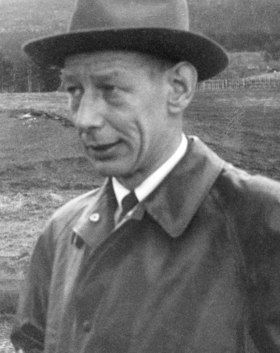 Portrett av mann, kledd i mørk frakk med kvit skjorte og slips under og med hatt på hodet. I Glomma fellesfløtingsforenings album er mannen identifisert som «Kons. Jahren». Bildet er antakelig tatt under ei fløtingsbefaring, og vi antar at «Kons.» er en forkortelse for konsulent. Dette kan være skogkonsulent Bernhard Riiser Jahren (1920-1992), som bodde på Lillehammer. Kopien av dette portrettet i Glomma fellesfløtingsforenings album er dessverre noe istykkerklippet og filmen til bildet later ikke til å være bevart.