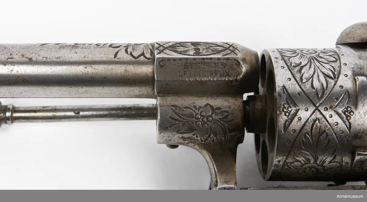 Revolvern är en 6-skotts av system Lefaucheux, märkt ”Systeme Lefaucheux”. En skruv som håller fast pipan saknas. Troligen cirka 9 mm kaliber och cirka 1870-tal.