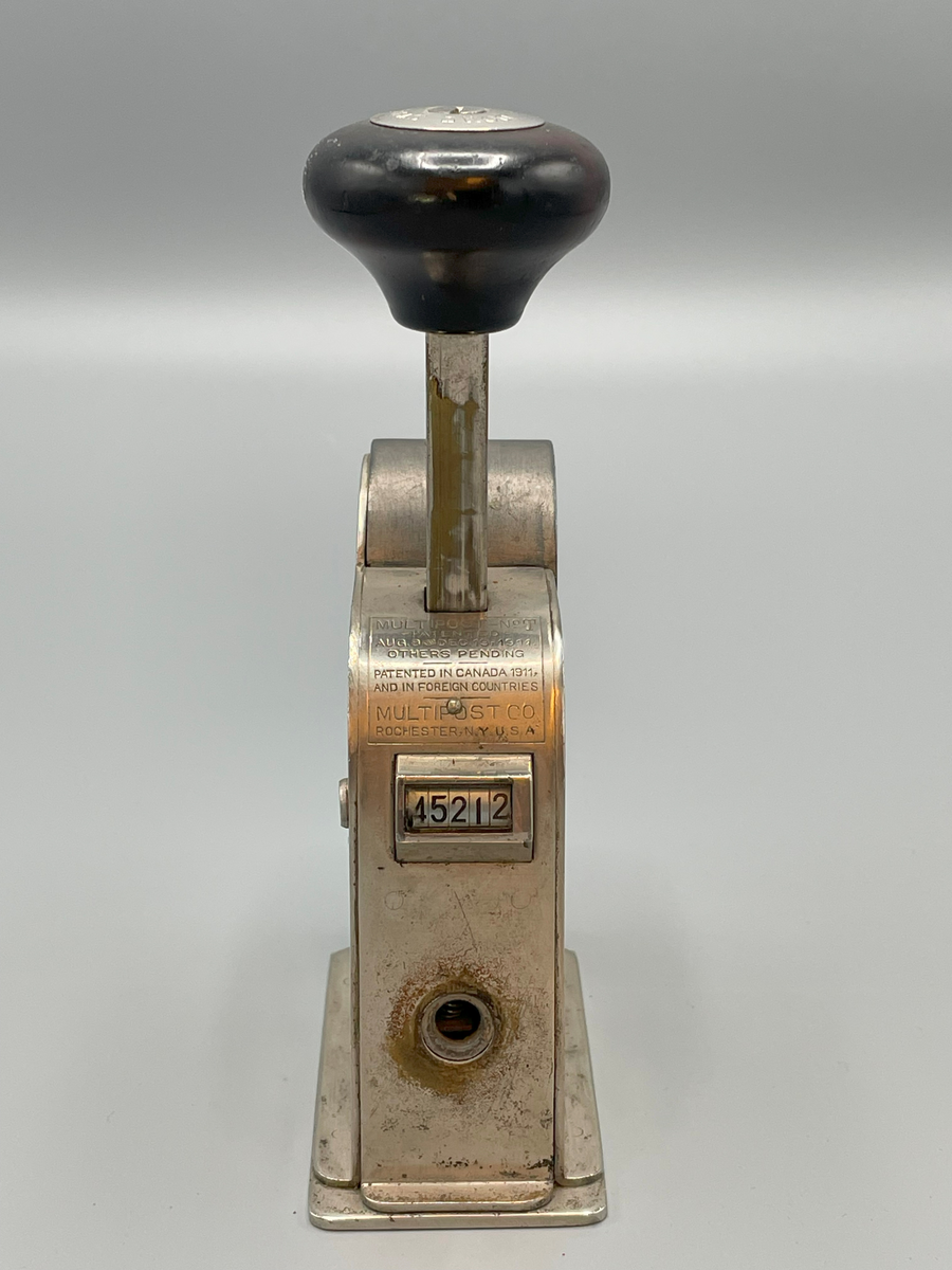 Frankeringsmaskin av amerikansk tillverkning, handtagsknopp av trä.

Multipost no T
Patented
Aug 8 and Dec 19 1911
Others pending
-----
Patented in Canada,
and in foreign countries
Multipost Co

