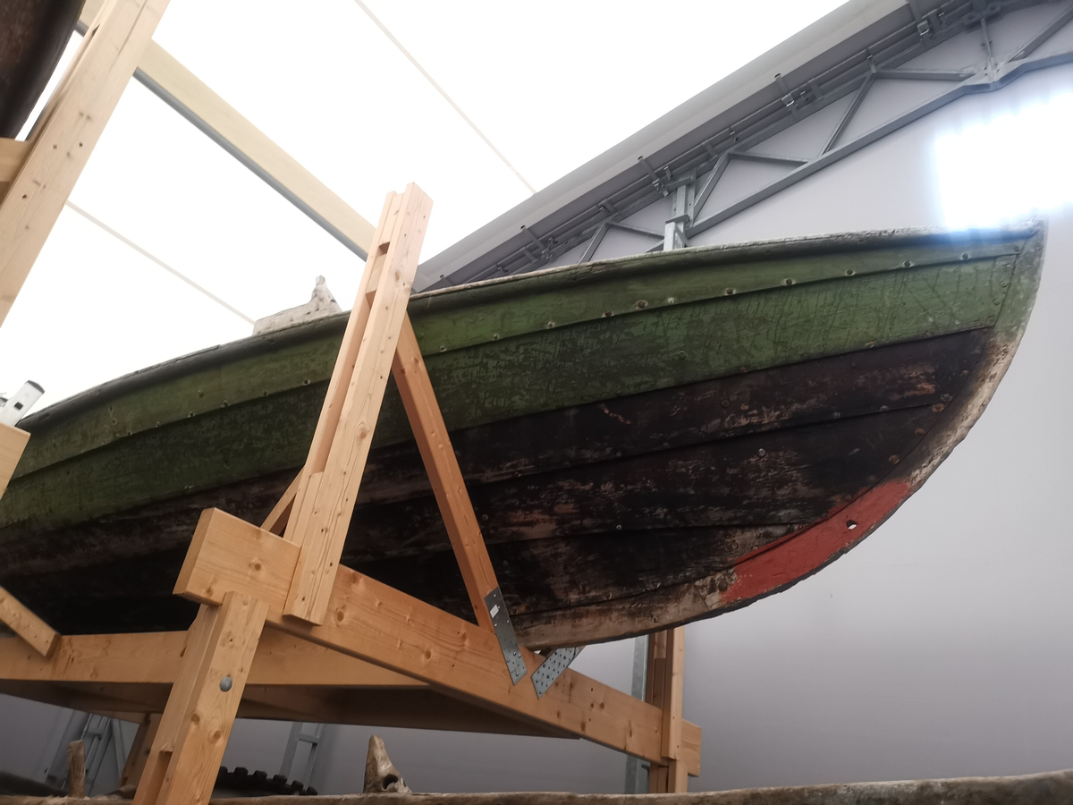 Klinkbygd nordfjordbåt, ein ekspedisjonsbåt, av type føring/firroing/firkeiping med 4 rom og 5 omfar, men har berre 3 keipepar. Utvendig er dei øvste borda grønmåla. Svart under, og svart maling /tjære inni båten. T-kjøl. Snelle mellom band og bete. Middels bredde mellom kjølsuene. Hogde halsar.  Båten har æsing øvst på innsida av ripbordet som ein båt sørfra. Utvendig langise. Vaterbord og skvettbord, med keipar på oversida. Firkanta "heimesmidde" roer. Det nedste omfaret har runde roer og ingen profilering - kan tyde på ombygging. Stråkjøl. Veldig korte stamnar. Rorinnfestning, har truleg hatt segl, men pga. skifta ripbord er det no ikkje spor etter hol for råsegl skjøte.