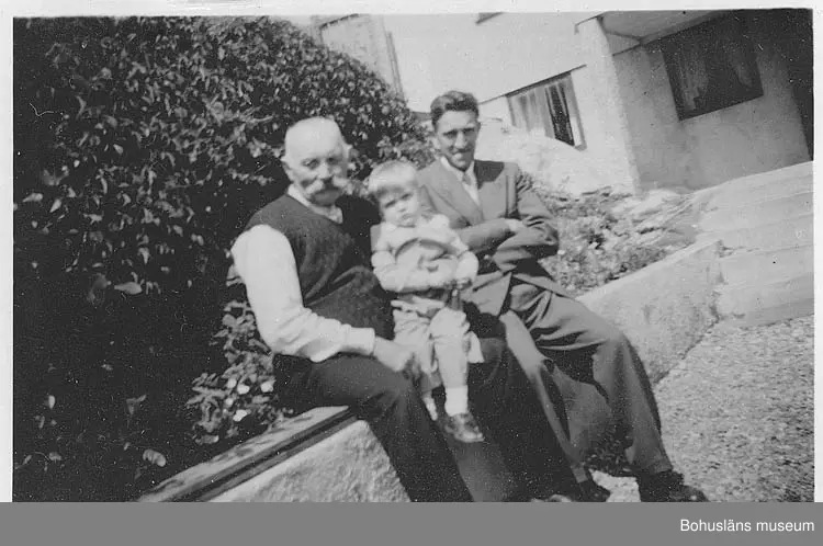 Enligt uppgift: "Varvsägaren och båtbyggaren Viktor Löfberg (1878-1962) med sonen Tore (1915-1979) och sonsonen Tomas, f. 1948, utanför Viktor Löfbergs hus i Rönnäng, ca 1950 
Viktor Löfberg grundade V. T. Löfbergs slip- och båtvarv i Rönnäng 1919 som sedan drevs vidare av sonen och sonsonen".