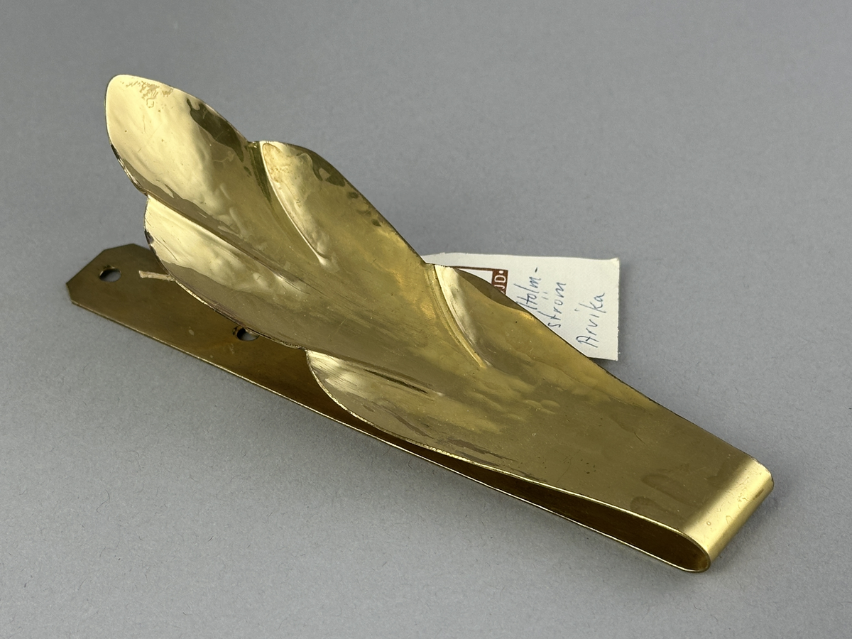 Gardinomtag av mässing med framsida i form av löv.