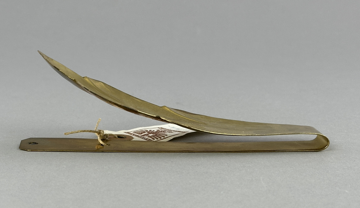 Gardinomtag av mässing med framsida i form av löv.