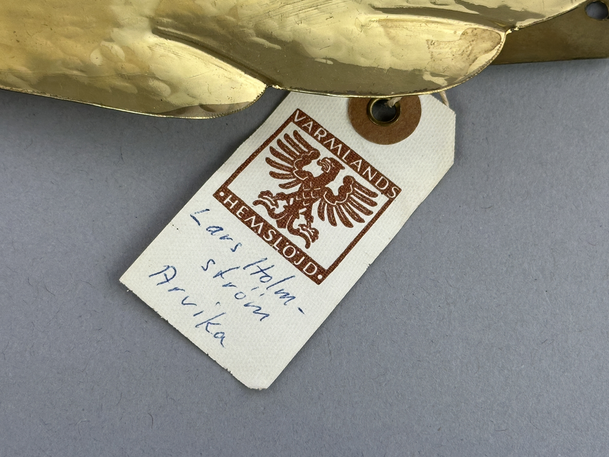 Gardinomtag av mässing med framsida i form av löv.