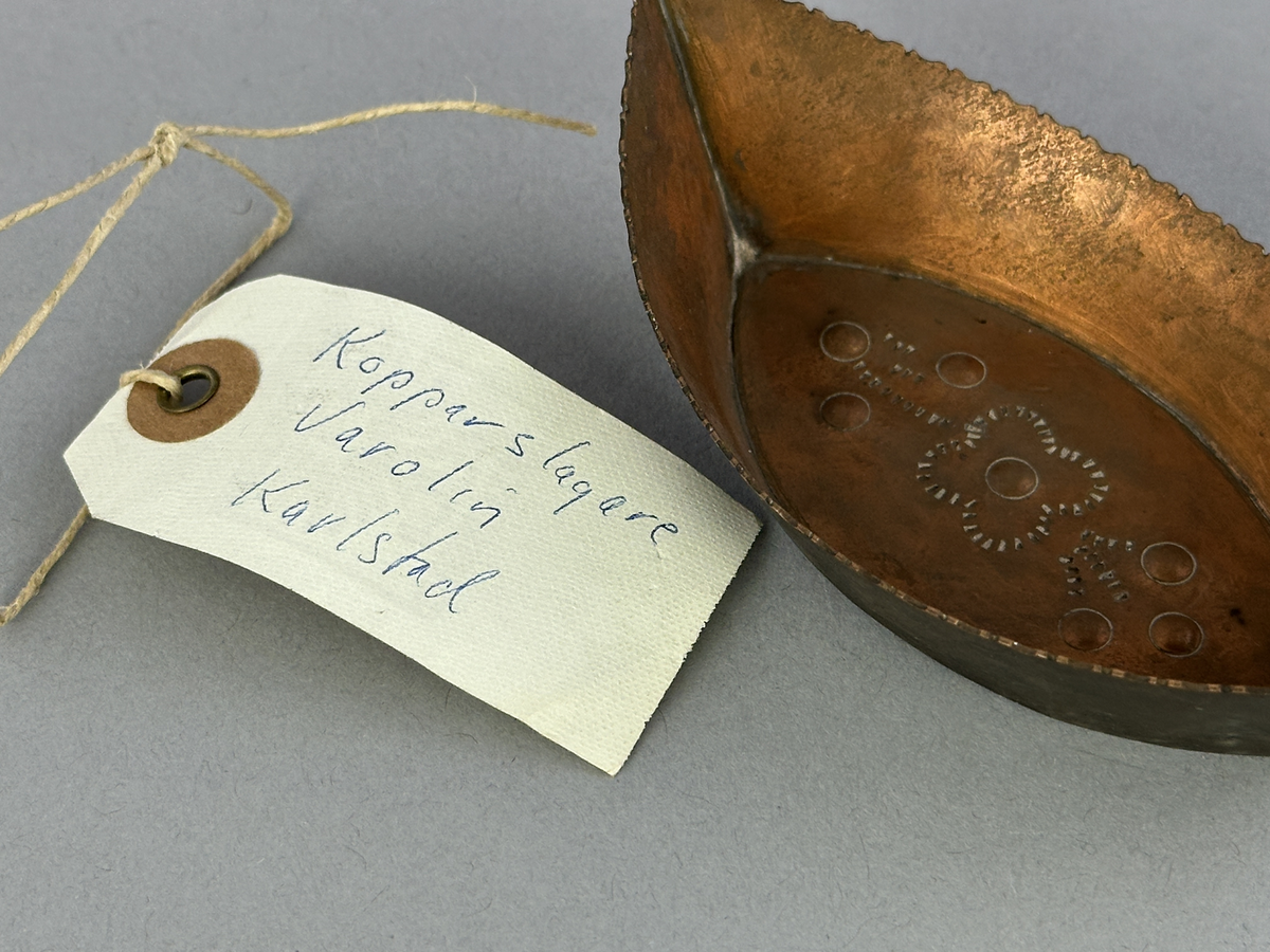 "Skål" av koppar, formad som en båt med mönster i botten.