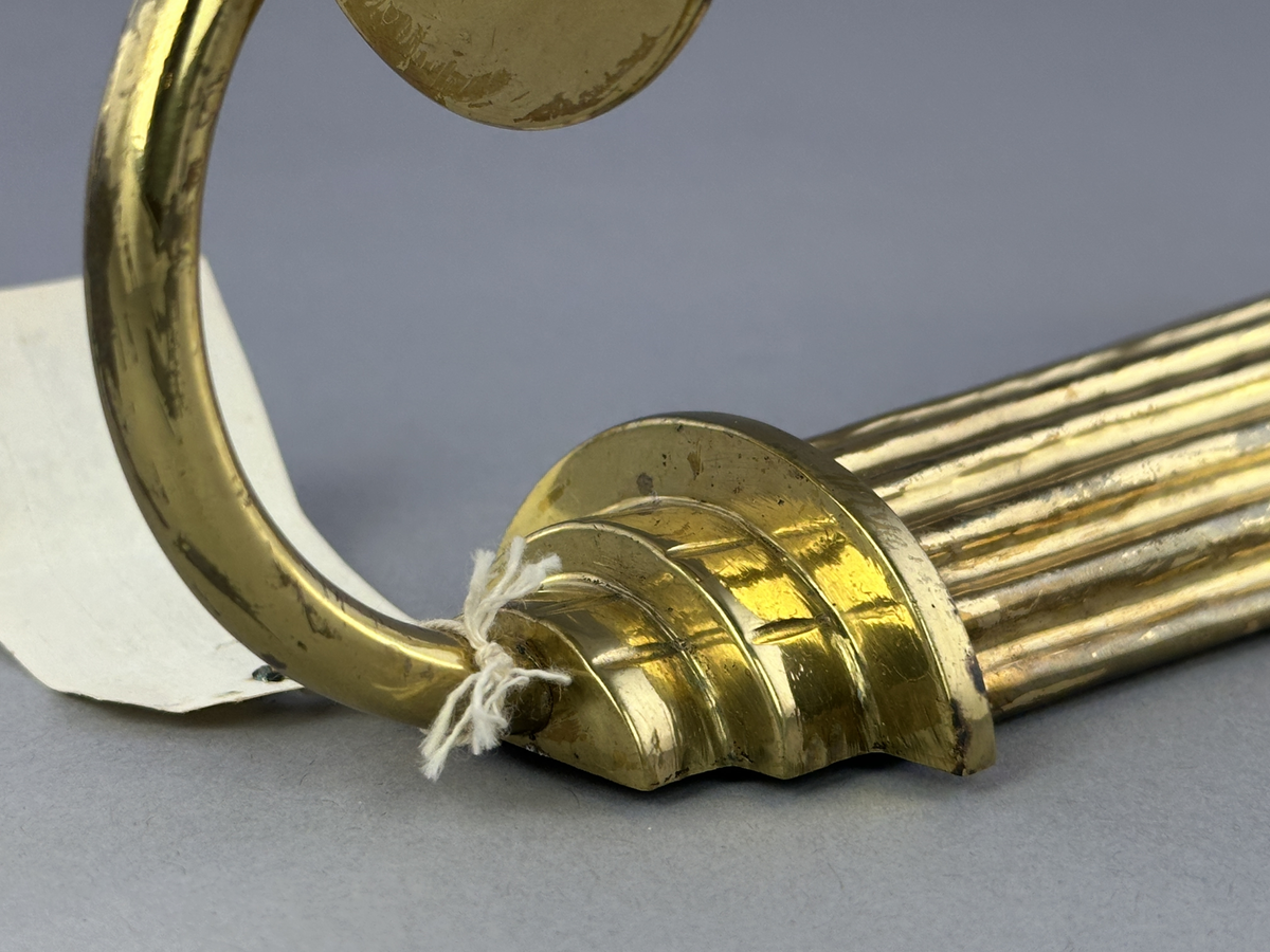 Lampett av mässing för ett ljus med gjutet armfäste för ljushållare.