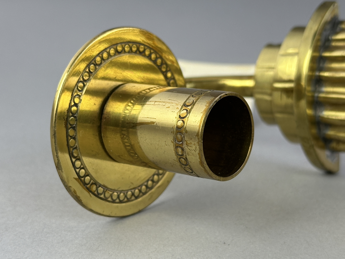 Lampett av mässing för ett ljus med gjutet armfäste för ljushållare.