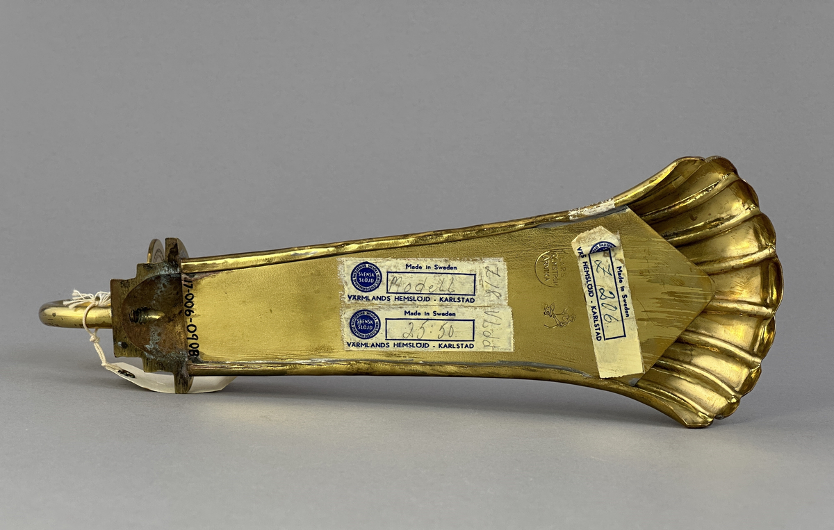 Lampett av mässing för ett ljus med gjutet armfäste för ljushållare.