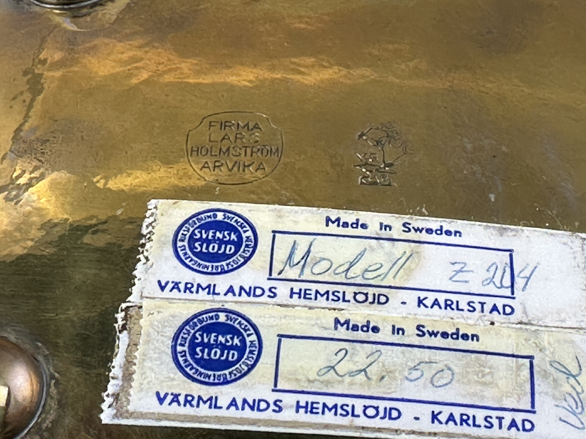 Fat av mässing på fyra fötter med dekorerad kant.