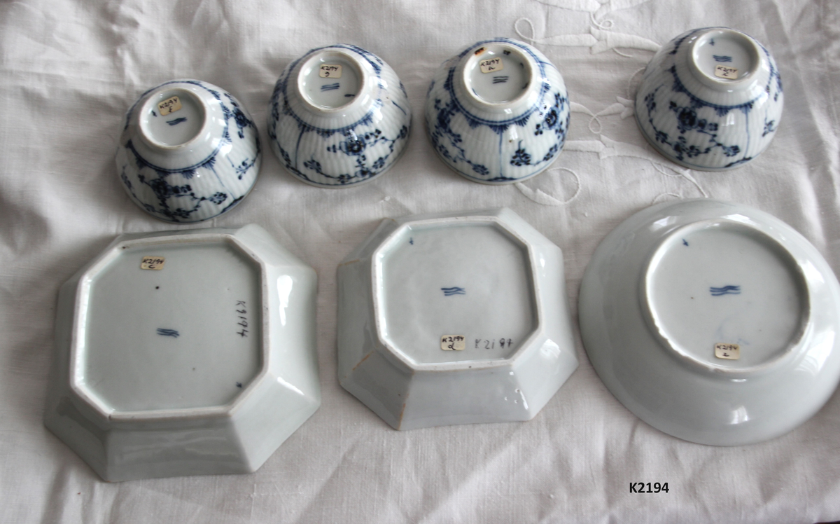 K 2194, a,b,c,d,f,l,g,h. 
Servise, stråmønstret, “musselmalet”, Kgl . Dansk Porselensfabrik, København. 
Porselen, hvitt og blått. Stemplet med tre bølgeliner, stempeltype fra 1775 og fremover, (De tre bølgelinjer symboliserer de tre viktigste vannveiene fra Danmark til baltisk område, i bruk fra 1775). 
Små blåmalte kryss og andre små merker. 
a) Fløtemugge, på tre føtter, vid hank, trekantet tut med hjerteformet åpning på toppen, nedsenket kant i munningens innside. 
b) Sukkerkopp med lokk.Rette sider, stempel innv. i bunnen, hvelvet lokk med bærformet knott. 
c) Åttekantet skål. 
d) Som c) men mindre. 
e) Skål. Rund side, dyp.
flgh) 4 kopper, uten bank. Alle har avslipte merker etter hanker.