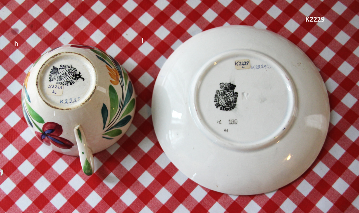 K 2229 
Servise, “Bondemønster”, Saarreguemines, 1900-åreme 
a) Terrin med lokk. 
Lokk. Hvelvet, bred bord langs kanten: grønn gren med røde og blå blomster, rund hankering med røde blad. 
b) Ovalt fat, med bord i brede strøk over bremmen. 
Stemplet i sort: Opaque de Saaregemines, H 169 A. 
c) Ovalt fat. Stemplet fabrikk merke og H 169 W. 
d) Ovalt fat. Stemplet i sort og i godset: 5 K. 
e) Båtformet skål (til pålegg). Avlang rned svakt svungne sider og konkavt buet i kortsidene. 
f) Make til e. 
g) Stettefat. 
h) Kopp. Vid rundsidet kopp, uten stett, forholdsvis lav. Stemplet i sort. 
i) Skål til koppen h).  Stemplet i sort. 
j) Kaffekanne, Pæreformet korpus, bølgende toppkontur, lang tut. Stemplet i sort og 169. Hvelvet lokk med rød toppfarge på lokkgrepet.
k) Fløtemugge, skrånende sider, riller oppe og nede , rillet hank, annerledes enn på den C-formede på kannen.
l) Sukkerkopp med lokk. Skrånende vegger, bredest nede, to hanker, riller oppe og nede, avtrappet lokk. Høyde med lokk 12,5. H. uten 7,2. Diam. bunn 10,8. 
m) Sausekopp. Eggformet skål med en skjellform i relieff , markert med rød farge, i den ene kortside, hvor hanken er. Smal liten skål med bred tut.
Fløtekopp og sukkerkopp av en annen design enn kanne, terrin og sausenebb, men samme mønster. Mønstret er det som kalles “Boerenbont” (broget bondemønster) og som ble laget først i Maastricht 
i Nederland, siden tatt opp av fabrikken Saarreguemirnes i Lorraine,og av Egersund Fayencefabrik i 1930-årene. 
n) Båtformet skål. Som e) Stemplet med sort. 
o) Ovalt fat. Stemplet Sarreguemines med sort og B 169. 
p) Terrin med lokk, stemplet med sort, og L i blindstempel.
Skrå fot, sterkt utskrånende sider, rundet av øverst, to sidehanker.
q) Underfat til terrin, rundt med to hanker. St. med sort og blindstempel: 3 R.
r) Potetfat. St. med sort og sort K.