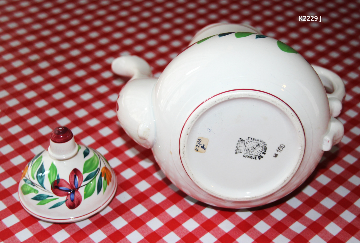 K 2229 
Servise, “Bondemønster”, Saarreguemines, 1900-åreme 
a) Terrin med lokk. 
Lokk. Hvelvet, bred bord langs kanten: grønn gren med røde og blå blomster, rund hankering med røde blad. 
b) Ovalt fat, med bord i brede strøk over bremmen. 
Stemplet i sort: Opaque de Saaregemines, H 169 A. 
c) Ovalt fat. Stemplet fabrikk merke og H 169 W. 
d) Ovalt fat. Stemplet i sort og i godset: 5 K. 
e) Båtformet skål (til pålegg). Avlang rned svakt svungne sider og konkavt buet i kortsidene. 
f) Make til e. 
g) Stettefat. 
h) Kopp. Vid rundsidet kopp, uten stett, forholdsvis lav. Stemplet i sort. 
i) Skål til koppen h).  Stemplet i sort. 
j) Kaffekanne, Pæreformet korpus, bølgende toppkontur, lang tut. Stemplet i sort og 169. Hvelvet lokk med rød toppfarge på lokkgrepet.
k) Fløtemugge, skrånende sider, riller oppe og nede , rillet hank, annerledes enn på den C-formede på kannen.
l) Sukkerkopp med lokk. Skrånende vegger, bredest nede, to hanker, riller oppe og nede, avtrappet lokk. Høyde med lokk 12,5. H. uten 7,2. Diam. bunn 10,8. 
m) Sausekopp. Eggformet skål med en skjellform i relieff , markert med rød farge, i den ene kortside, hvor hanken er. Smal liten skål med bred tut.
Fløtekopp og sukkerkopp av en annen design enn kanne, terrin og sausenebb, men samme mønster. Mønstret er det som kalles “Boerenbont” (broget bondemønster) og som ble laget først i Maastricht 
i Nederland, siden tatt opp av fabrikken Saarreguemirnes i Lorraine,og av Egersund Fayencefabrik i 1930-årene. 
n) Båtformet skål. Som e) Stemplet med sort. 
o) Ovalt fat. Stemplet Sarreguemines med sort og B 169. 
p) Terrin med lokk, stemplet med sort, og L i blindstempel.
Skrå fot, sterkt utskrånende sider, rundet av øverst, to sidehanker.
q) Underfat til terrin, rundt med to hanker. St. med sort og blindstempel: 3 R.
r) Potetfat. St. med sort og sort K.