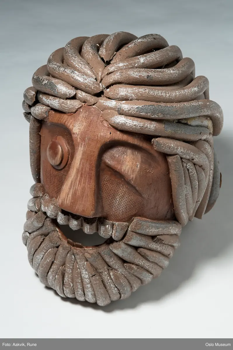 Heldekkende teatermaske (til hele hodet).
Brun gipsmaske med remser av skumgummi til hår og skjegg.