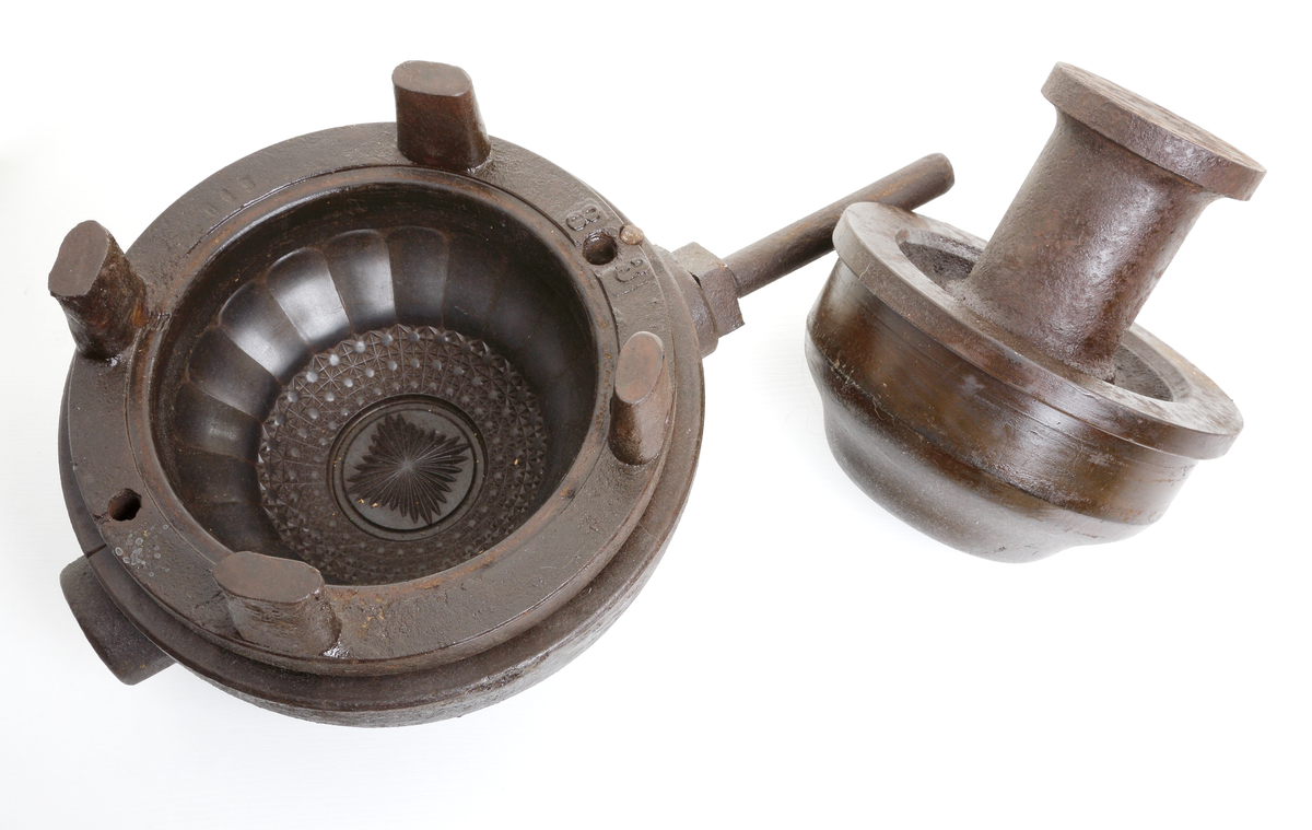 Form för pressning av glas. 
Föremålet är i tre delar: Form, ring och malle.
Vid pressning erhålles en skål med stjärna i 
botten, ett "brodyrmönster" på buken, och 
rak "räffling" från centrum mot valvbågskanten. 
Invent. 1996-02-26 och 2006-05-12
Inskriven i huvudkatalogen 1996.

Finns på basutställningen "På väg" 1800-tal,
2006-09-07 och framåt.
Funktion: Att pressa glas i