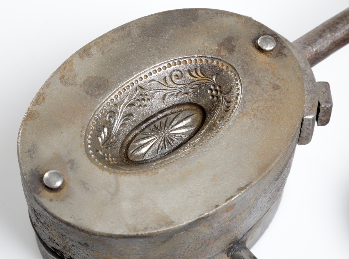 Pressglasform av gjutjärn för pressning av miniatyr-
eller dockservisskålar, bestående av en öppen form,
samt malle och ring. De båda handtagen, som sitter 
fästa på form och ring, avslutas med svarvade handtag. 
Invent. 2006-08-22
Inlagt i huvudkatalogen 2006.

Finns på Smålands museum, basutställningen "På väg"
1800-tal, från 2006-08-23 och framåt.
Funktion: Att pressa glas i