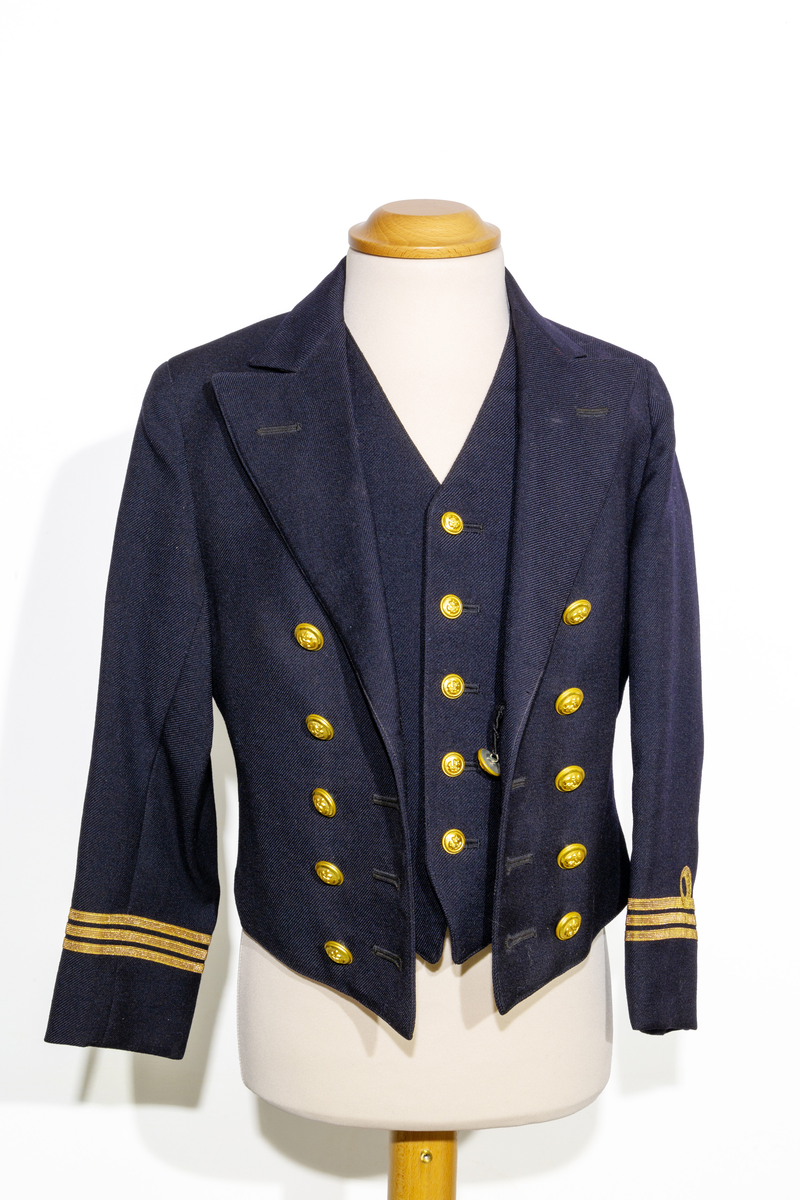 Uniformsjacka (marinen) till barn i mörkblått ylletyg. Försedd med fem rader av guldfärgade knappar med motiv av ankare. Ärmarna pryds av tre rader med guldfärgat band. Jackan är fodrar med ett svart tyg och ett randigt tyg med blå och bruna ränder på oblekt bas på ärmarnas insida. Jackan har en inneficka på höger sida. I jackans nackstycke finns en etikett med texten "Barngarderoben Falun" samt en hängare. 