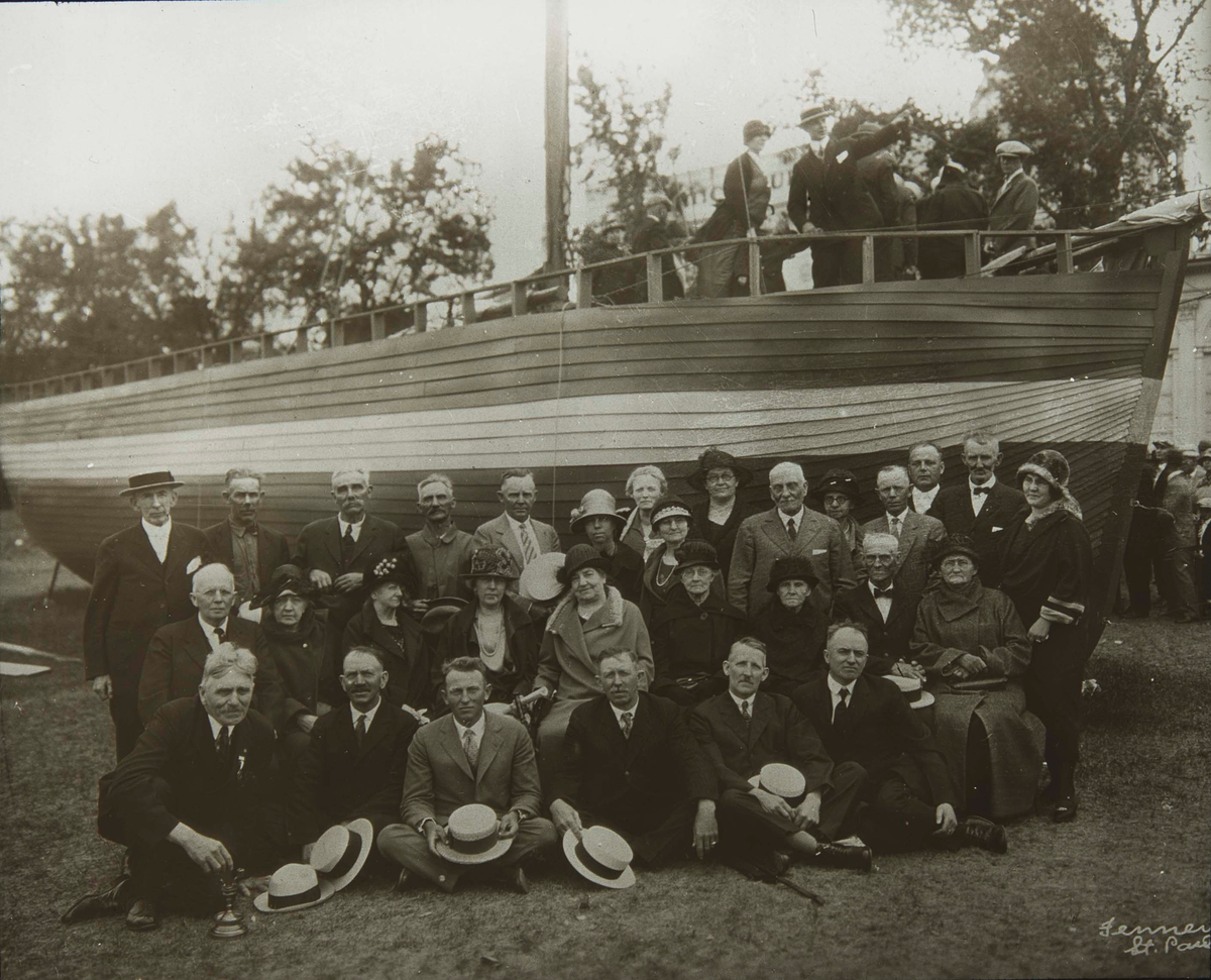 Etterkommere av "sluppefolket" samlet foran en båt.