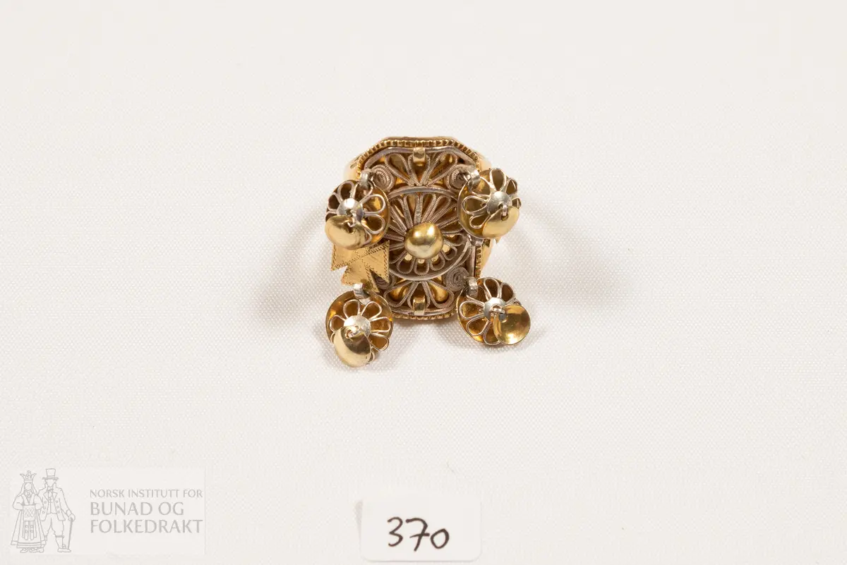 Fingerring. Forgylt sylvring. Dobbel ring med plate dekorert med filigransarbeid. Det same er dei 6 skålene.
Fleire stempel, blant anna 7 prikkar (Bergen bystempel), H.
