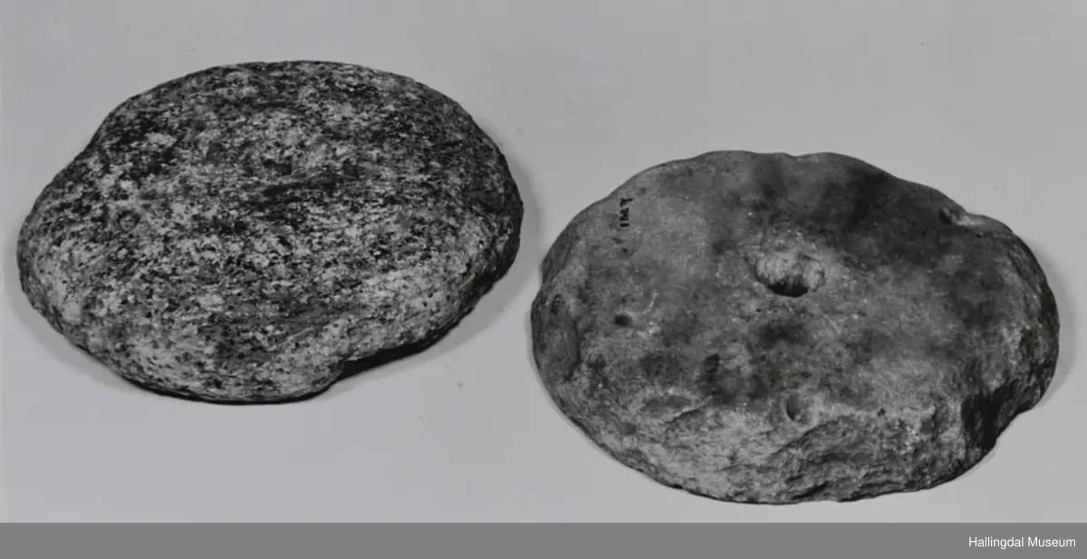 2 tilnærma sirkulære steinar med hol i midten.