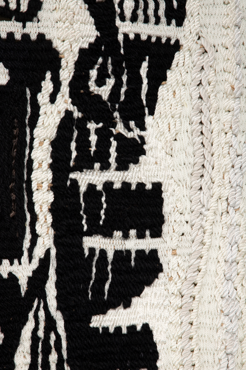 Motivet er todelt. Den ene halvdelen i hovedsak sort, den andre er sort hvit med motiv. Motivet viser dyresymboler, stilliserte ansikt og annet fordelt på tre horistonale felt. Motivet danner et mønster med en ornamental og repeterende karakter.