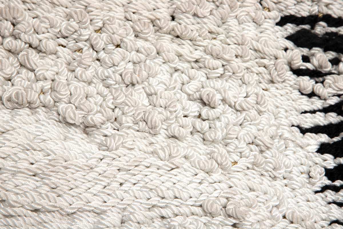 Motivet er todelt. Den ene halvdelen i hovedsak sort, den andre er sort hvit med motiv. Motivet viser dyresymboler, stilliserte ansikt og annet fordelt på tre horistonale felt. Motivet danner et mønster med en ornamental og repeterende karakter.