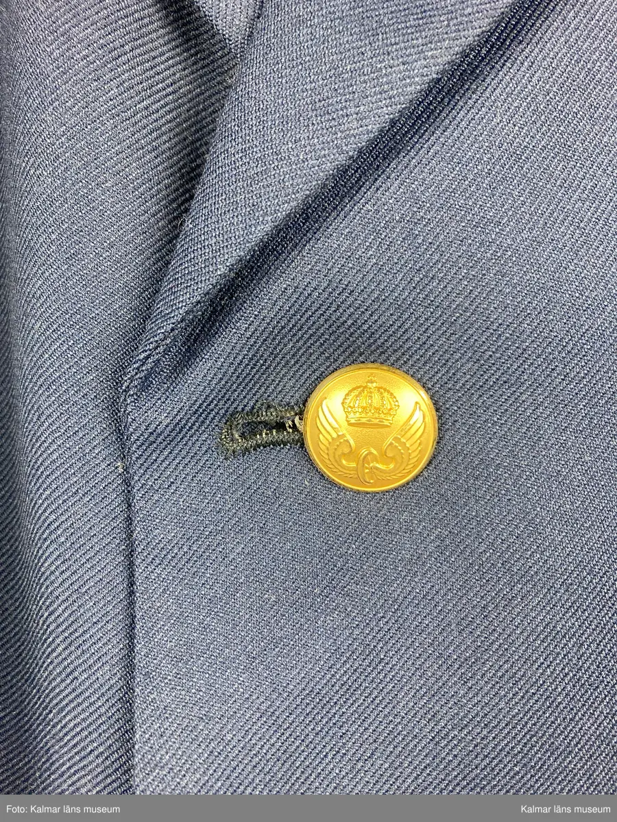 KLM 44463:9. Kavaj. Uniformsjacka för stins, SJ. Storlek C54. Av kypertvävt mörkblått ylle. Krage och slag. Knäpps fram med fyra st. knappar av gulmetall med SJ vapen på. Fickor med ficklock samt bröstficka, på vänster framstycke. Fodrad med mörkblått tyg i livet och grått i ärmen. Hank i nacken. Innerfickor på båda framstyckena. Textiletikett vid höger innerficka med vävd text: CBV C54 KARLSKRONA.  
Kavajen är av tunnare sort och har ev. använts som sommar kavaj till byxor KLM 44463:8:2 och väst KLM 44463:8:3.