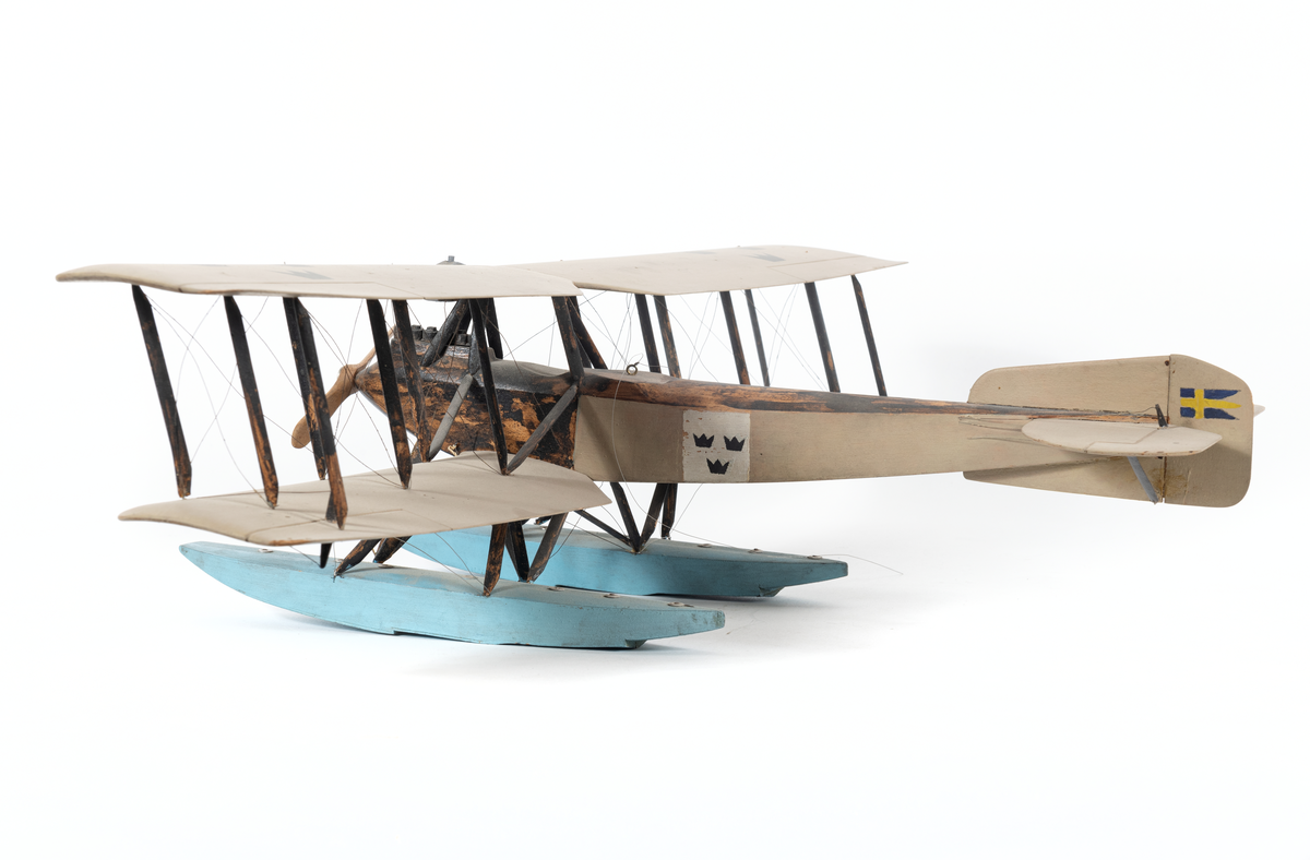 Modell av flygplan, Friedrichshafen FF 49. Enmotorigt biplan, två flottörer. Inbyggd flygkropp mellan vingarna. Smala, långa vingar, lika stora, bredare akterkant. Två horisontala roder på den övre. Stjärt med halvcirkelformad bäryta, två horisontala och ett vertikalt roder. Stöttor och stag av metall.

Gråmålat. Sittrum och flygkroppens översida svarta, flottörer blå. Tre svarta kronor på vingar och flygkropp. Svensk örlogsflagg på vertikalrodret.