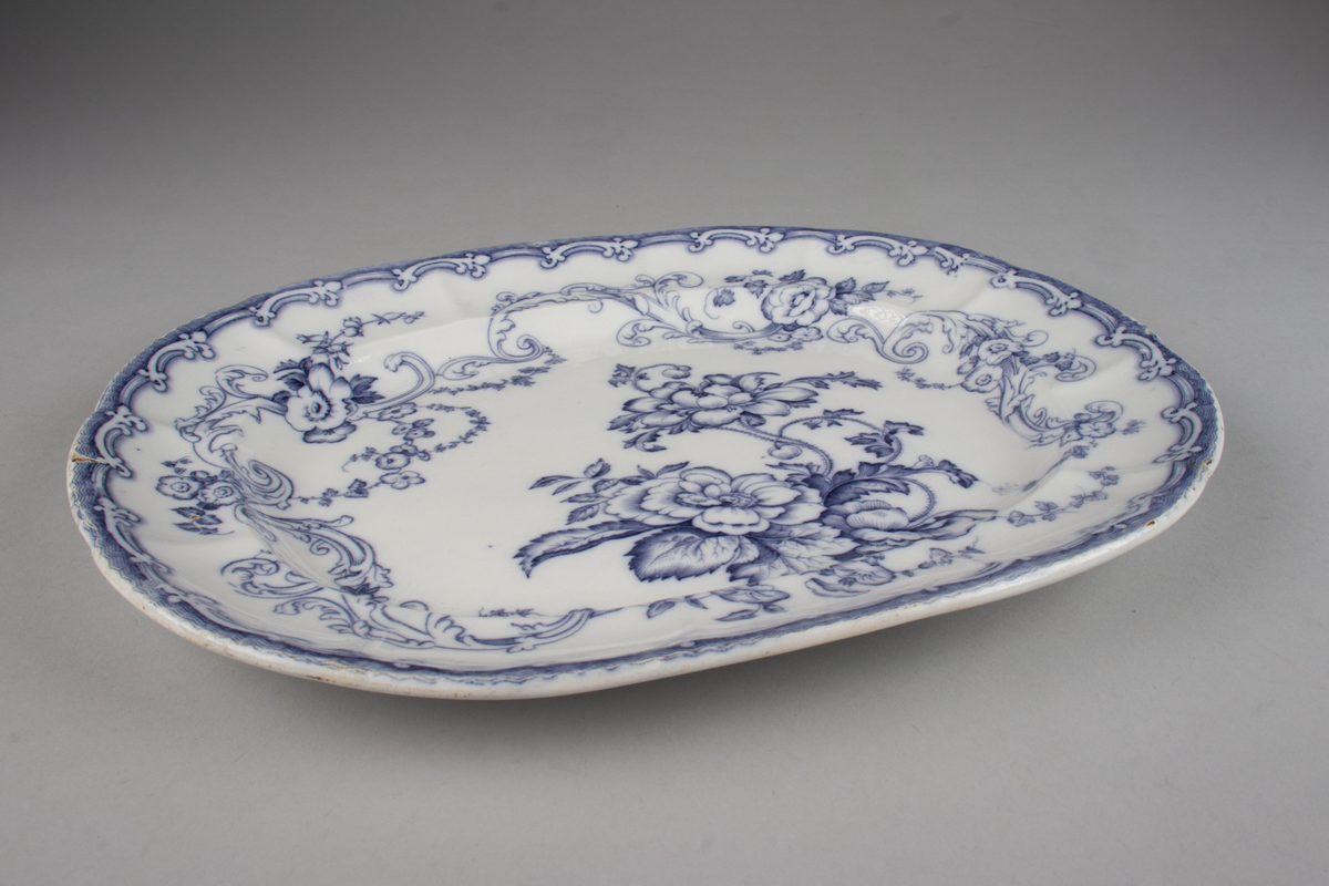 Stort, ovalt serveringsfat i hvitt porselen med blå dekor