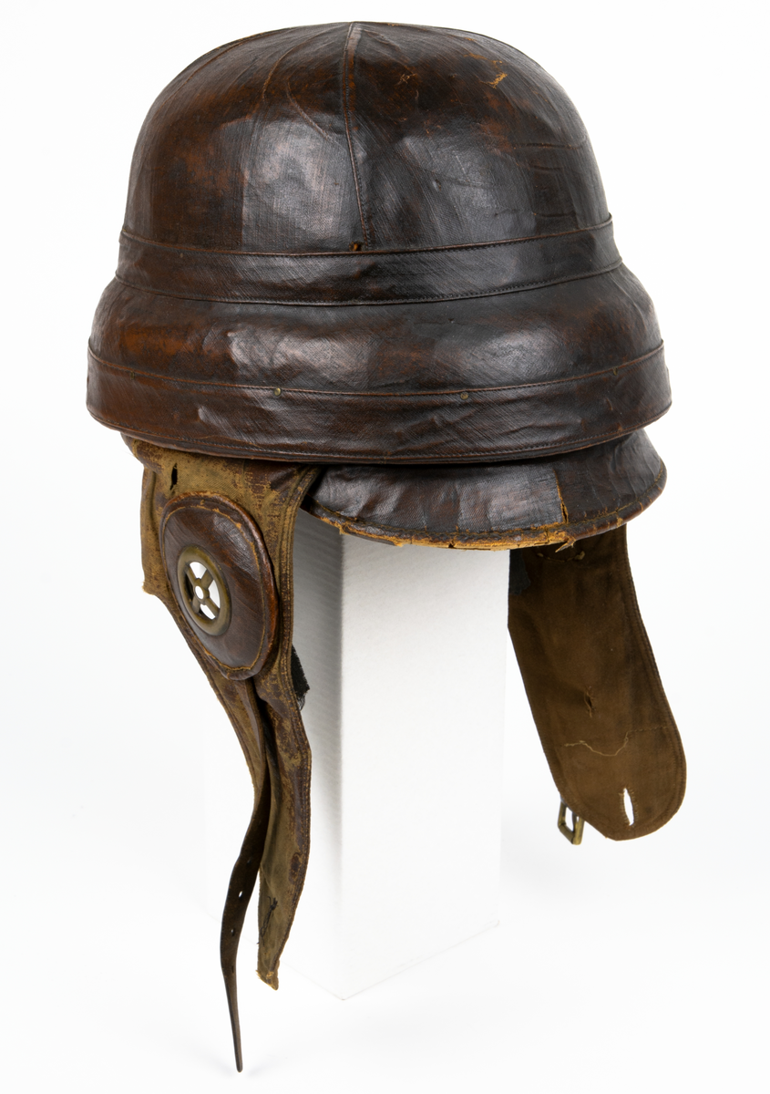 Flyghjälm av äldre model,l även kallad störthjälm eller störtpralin. På insidan texten: "Casque Protecteur Roold, BREVETÉ S.G.D.G."
På insidan en liten rund etikett med siffran 60.