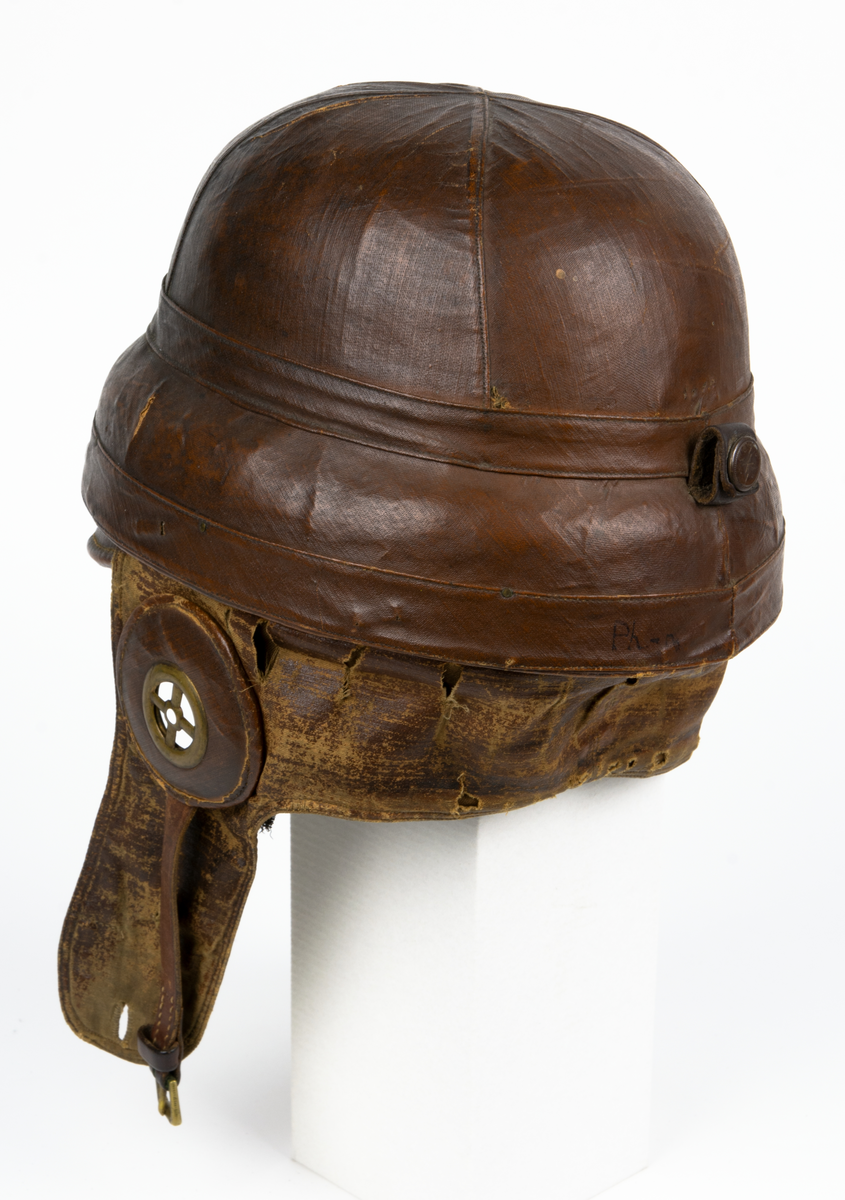 Flyghjälm av äldre model,l även kallad störthjälm eller störtpralin. På insidan texten: "Casque Protecteur Roold, BREVETÉ S.G.D.G."
På insidan en liten rund etikett med siffran 60.