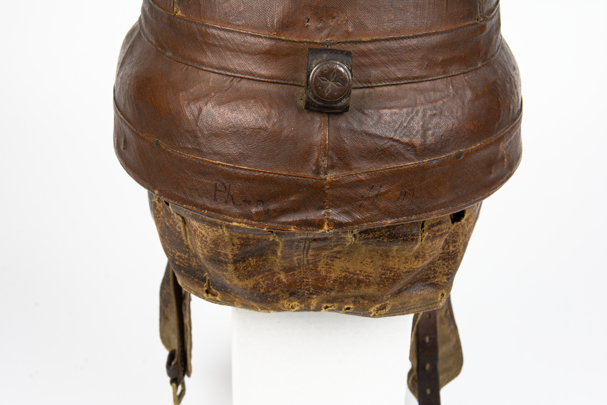 Flyghjälm av äldre model,l även kallad störthjälm eller störtpralin. På insidan texten: "Casque Protecteur Roold, BREVETÉ S.G.D.G."
På insidan en liten rund etikett med siffran 60.
