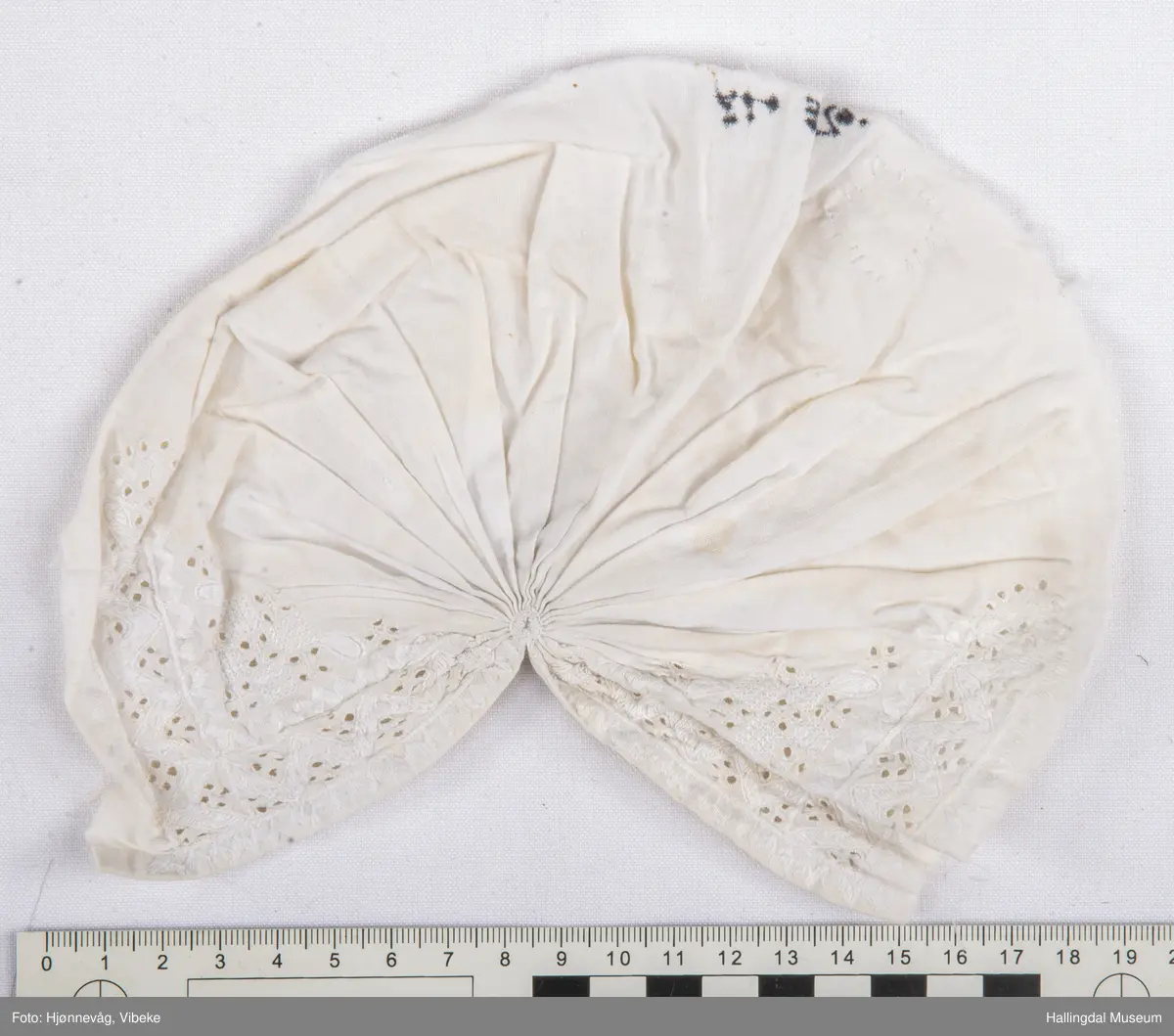 Bomullstoff, sydd og brodert. Kvitsaum.