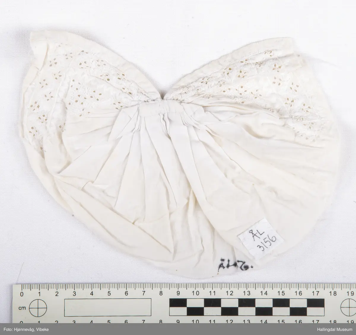 Bomullstoff, sydd og brodert. Kvitsaum.