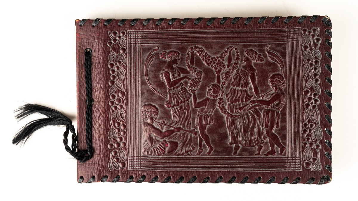 Fotoalbum, vinröda pärmar i pressat skinn. På framsidan figurer i relief i romersk eller grekisk stil. Baksidan med mönster i relief.  Bladen svarta med tunt papper som mellanlägg. Interiörfoton samt ett löst fotografi, ett porträtt. Text på insidan  "Gunvor Julen 1945 av Pappa".
Enligt anteckning ska albumet innehålla foton från Centralpalatset i Gävle.