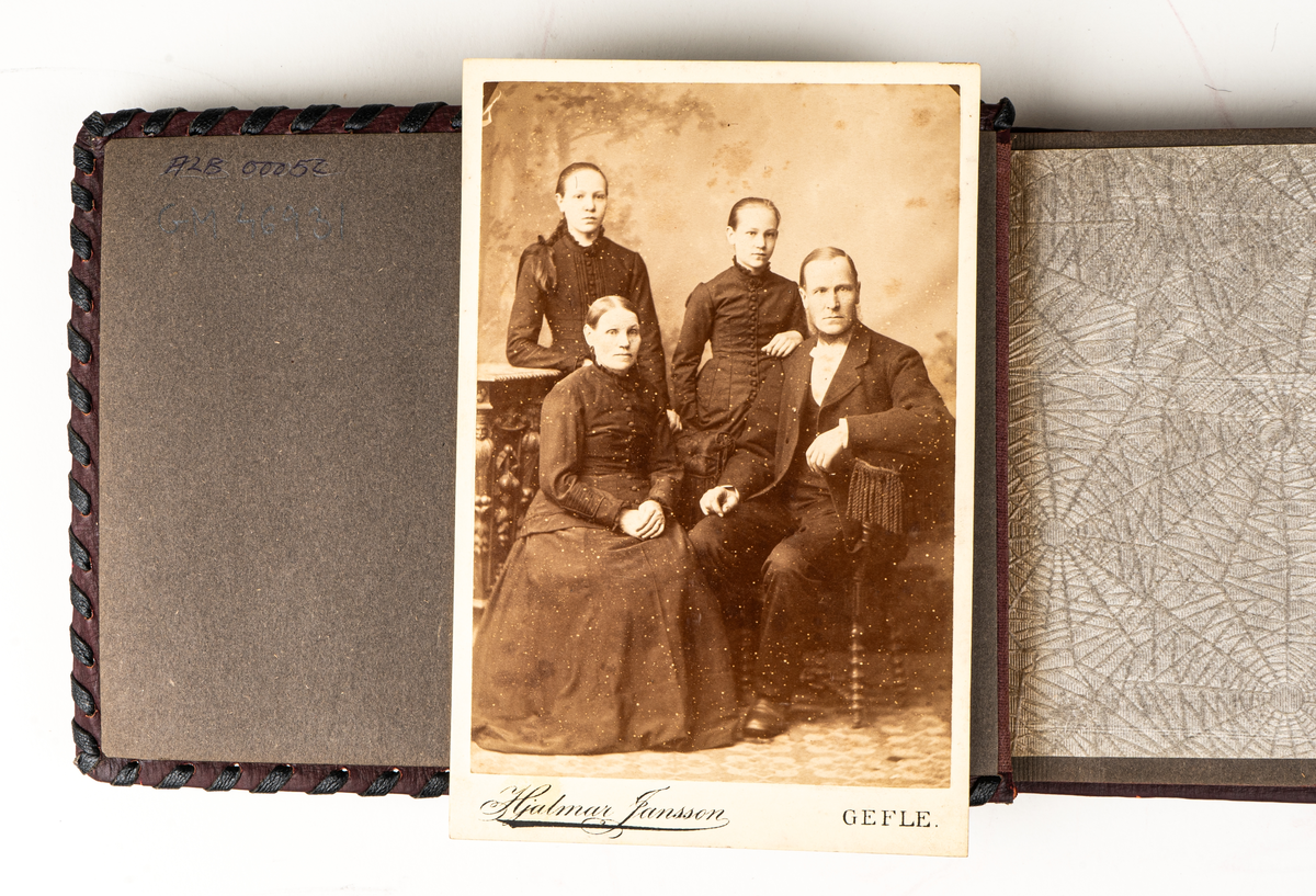Fotoalbum, vinröda pärmar i pressat skinn. På framsidan figurer i relief i romersk eller grekisk stil. Baksidan med mönster i relief.  Bladen svarta med tunt papper som mellanlägg. Interiörfoton samt ett löst fotografi, ett porträtt. Text på insidan  "Gunvor Julen 1945 av Pappa".
Enligt anteckning ska albumet innehålla foton från Centralpalatset i Gävle.