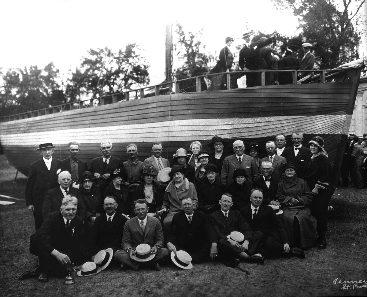 Etterkommere av "sluppefolket" samlet foran en båt.