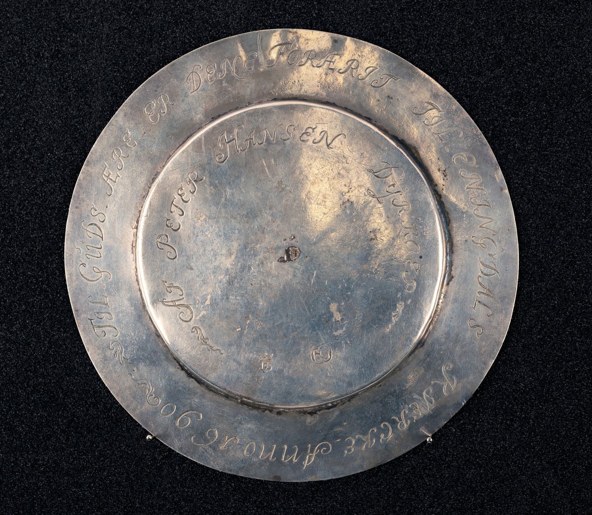 Fra protokoll: Skål av sølv med malteserkors og guds lam. Under bunnen gravert. Stemplet: se foto.