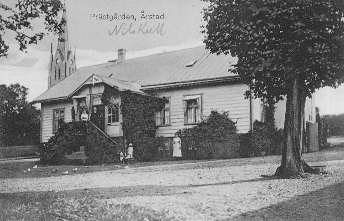 Vykort föreställande Årstad prästgård. Kyrkans torn syns bakom huset.