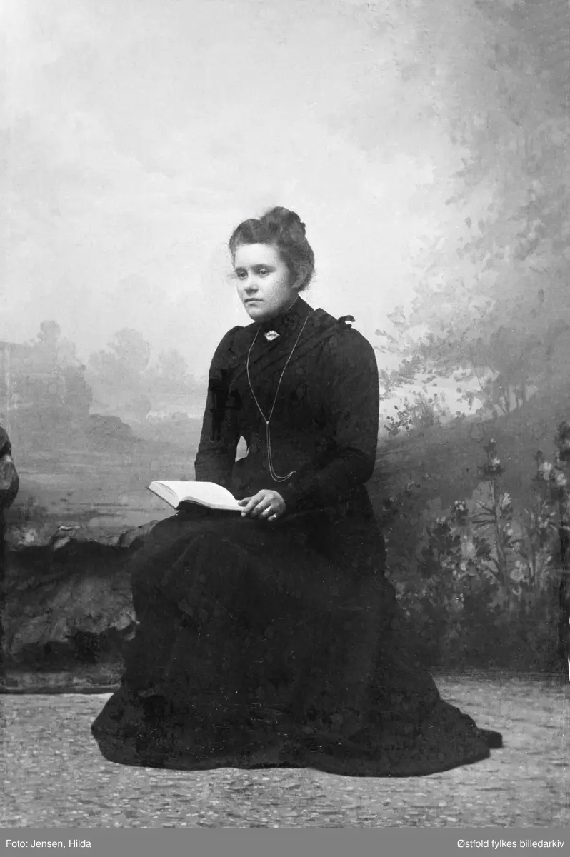 Portrett i visittkortformat av Helga Lilleng. Jordmor i Varteig fra 1909, flyttet til Sarpsborg i 1914. Gift med Even Hasle som omkom i en ulykke i 1914.