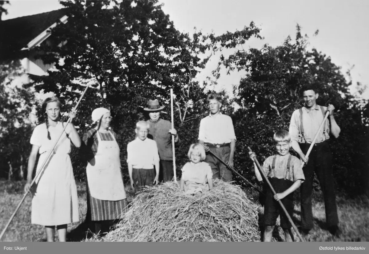 Høyonn på Stubberud i Varteig ca. 1935. Fra venstre: Magda, Martha, Jens, Martin Mathisen, Helge og Henrik. Foran Solveig og Hans - alle med etternavn Spydevold.