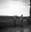 Hemvärnet. 20/4, 1941.
Två män i hemvärnsuniform diskuterar något vid en landsväg.