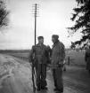 Hemvärnet. 20/4, 1941.
Två män i hemvärnsuniformer diskuterar något på landsvägen vid
granallén till Teleborgs slott.
I bakgrunden skymtar bl a sjön Trummen.