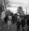 Gymnastikuppvisningen, 25/5 1941. 
En gymnastiktrupp, med några kostymklädda herrar och en fanbärare
i täten, marscherar fram längs Storgatan.