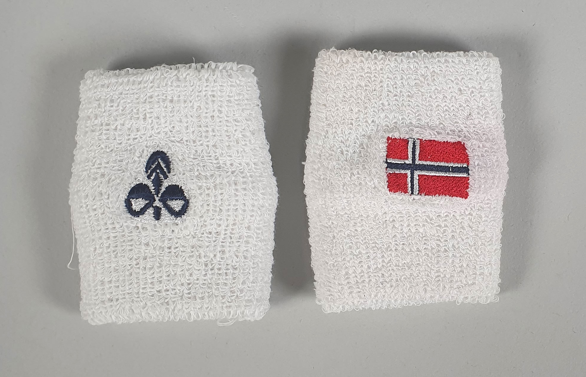 Mørkeblå håndballdrakt bestående av t-skjorte, shorts og svettebånd til håndledd. T-skjorten har hvite kantbånd i halsen og ytterst på ermene, en rød stripe i sidene, og et norsk flagg i en hvit ring på brystet. Buksa har knytebånd i livet og norsk flagg i en hvit ring nederst på venstre side, og tallet 10 nederst på høyre side foran.