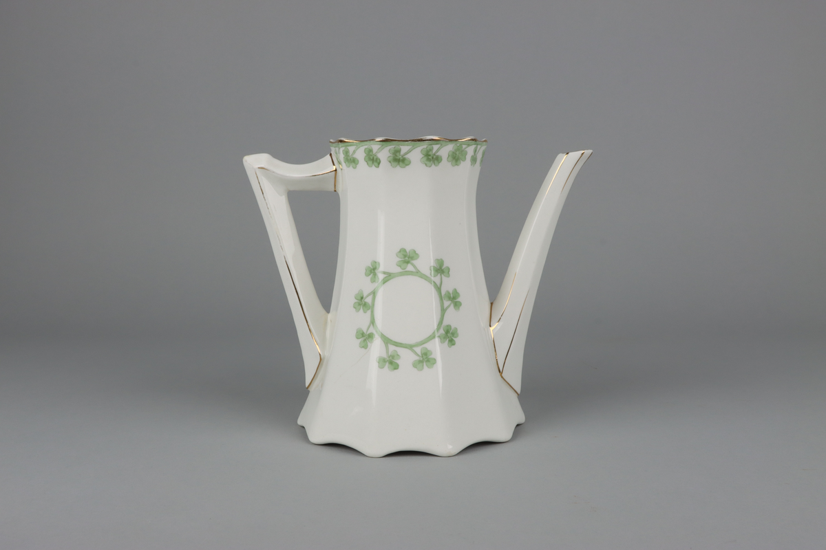 Kanna till kaffekanna med lock. Åttkantig klockad form som nedtill avslutas med vågig kant och upptill en något utvikt mynning.  Handtag och pip med en facetterad form. På kannan mitt fram och mitt bak krans med treklöverblad. På handtag och pip förgyllda smala lister. Under botten tryckt fabriksstämpel med Gustavsberg och servisnamn Gunnar.