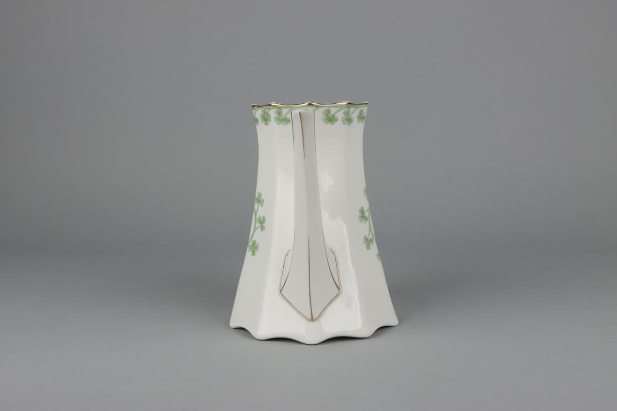 Kanna till kaffekanna med lock. Åttkantig klockad form som nedtill avslutas med vågig kant och upptill en något utvikt mynning.  Handtag och pip med en facetterad form. På kannan mitt fram och mitt bak krans med treklöverblad. På handtag och pip förgyllda smala lister. Under botten tryckt fabriksstämpel med Gustavsberg och servisnamn Gunnar.