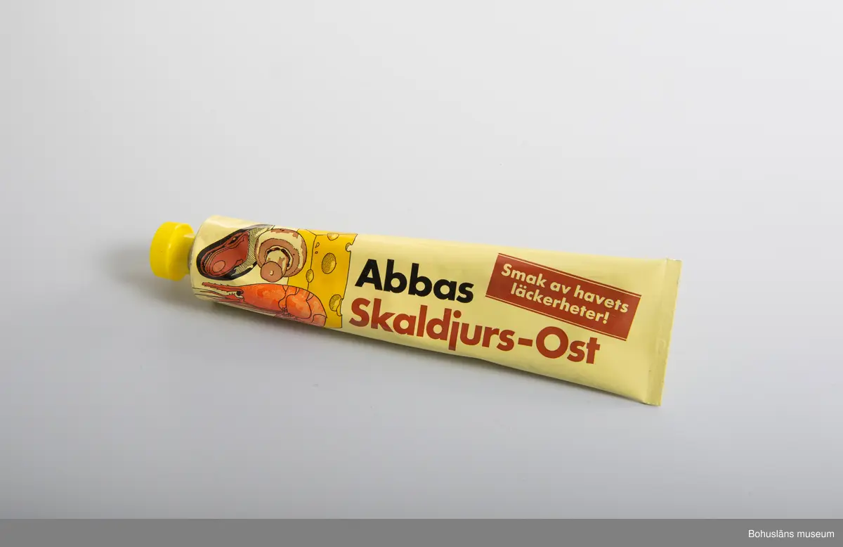 471 Tillverkningstid 1970-1990
410 Mått/Vikt !L 20,5, B 5,5 CM
106 OCM *255,348
594 Landskap BOHUSLÄN
503 Kön MAN
394 Landskap BOHUSLÄN
601 tryckt dekor i gult, bruntrött. svart. Gjuten gul plasthatt.
602 Text:"Abbas Skaldjur4s-Ost. Smak av havets läckerheter"
603 På  baksidan innehållsdeklaration och prismärkningskod
604 Om givaren se UM 26667