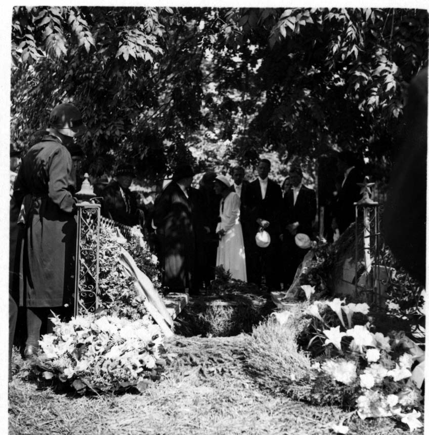 En folksamling under skuggan av träd; "släkten vid graven".