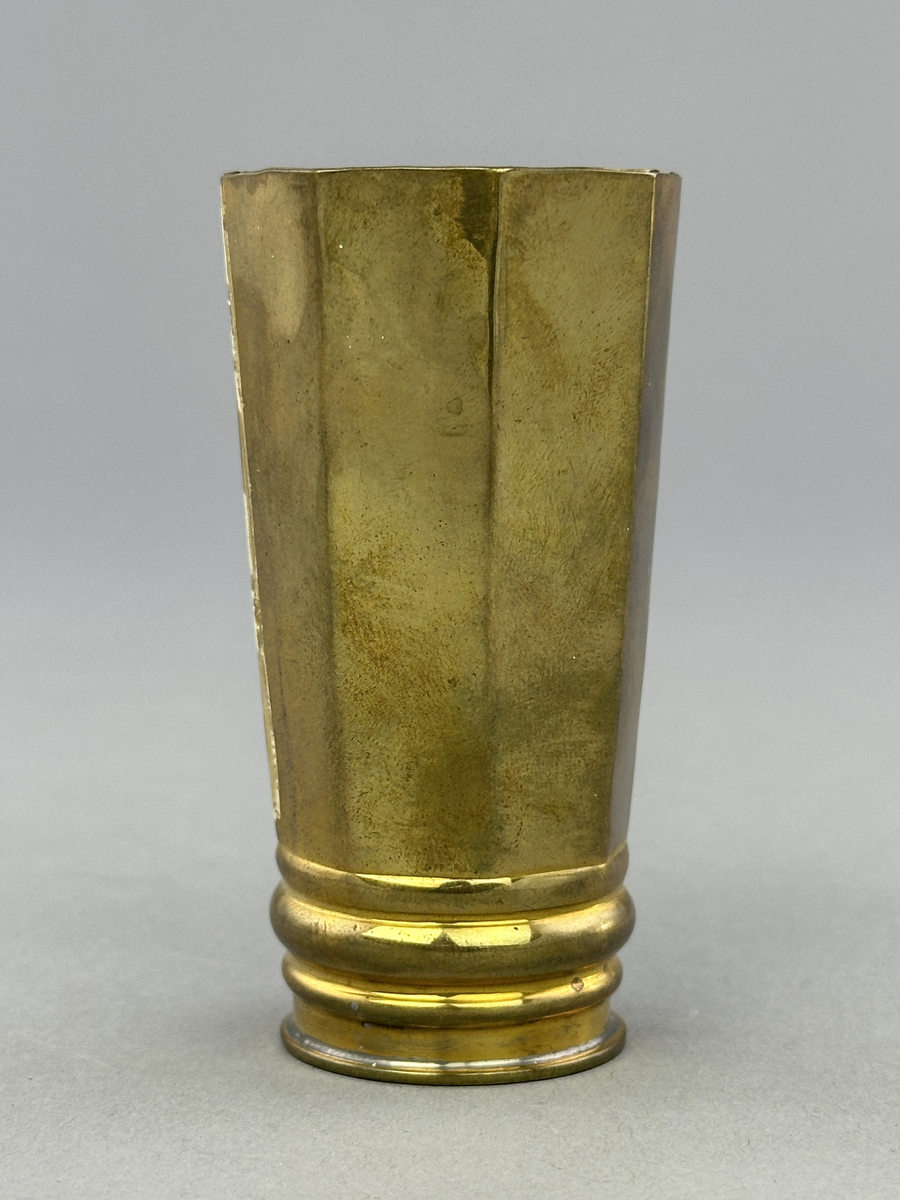 Vas av mässing med rund botten och åttkantig överdel.